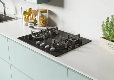 A modern kitchen countertop with a built-in gas hob and decorative items.