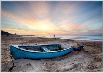 Produktbild von Wallario Wandbild Fischerboot am Strand bei Sonnenuntergang, Größe: 70,30 x 100,30 cm, Poster mit weißem Kunststoffrahmen