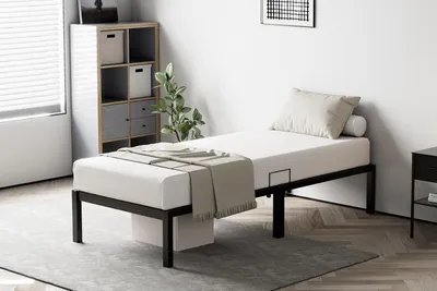 A bedroom setting with a bed, nightstand, and storage unit.