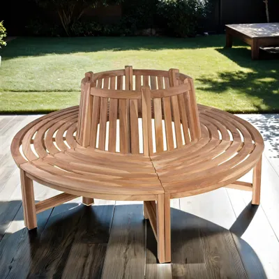 A circular wooden bench is placed on a wooden deck in a garden setting, with a lawn and trees in the background.