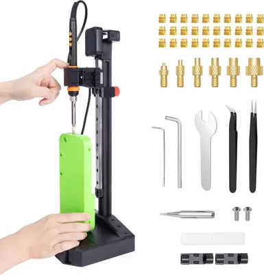 A person's hands are shown operating a vertical heat set insert press tool with a soldering iron, demonstrating its use on a green component. Various accessories are laid out to the right.
