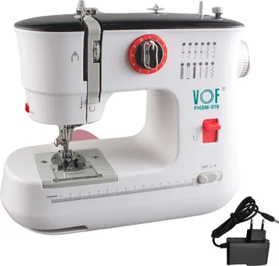 A white electric sewing machine with black accents and red dials, shown on a white background. A power adapter is visible in the lower right corner.