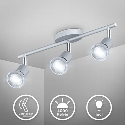 A silver-colored ceiling spotlight with three adjustable heads is mounted on a white ceiling.