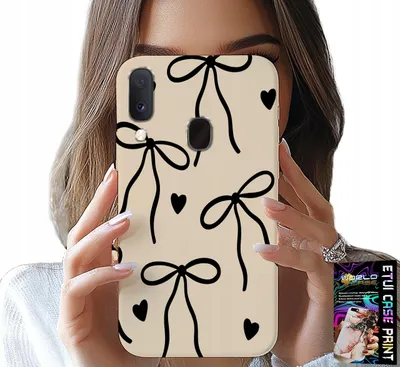 A person is holding a phone case with a bow pattern in front of their face.