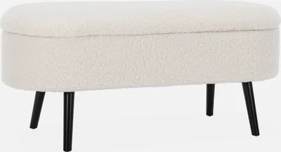 A studio shot of an ecru bouclé storage bench with black legs.