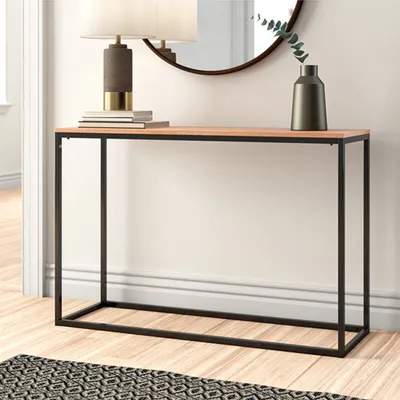 A console table with a lamp and vase on top, placed in a hallway or living room.