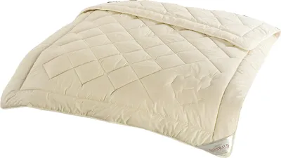 A cream-colored comforter is laid out on a white surface.