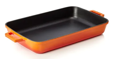 A rectangular baking dish with orange exterior and black interior, shown from a slightly elevated angle on a white background.
