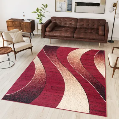 A modern living room with a brown leather sofa, a wooden cabinet, a chair, and a rug with a wavy pattern.