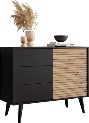 A modern black and wood dresser with decorative items on top.