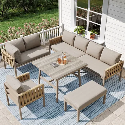 An outdoor patio set on a deck with a railing and greenery in the background.