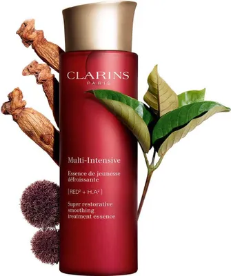 A red bottle of Clarins Super Restorative Smoothing Treatment Essence is displayed with natural elements like ginseng roots and leaves.