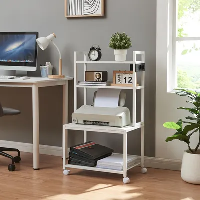 A home office setup with a desk, computer, lamp, and a rolling printer stand.
