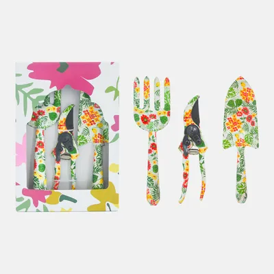 A set of three gardening tools with a floral pattern, displayed in a box and next to it.