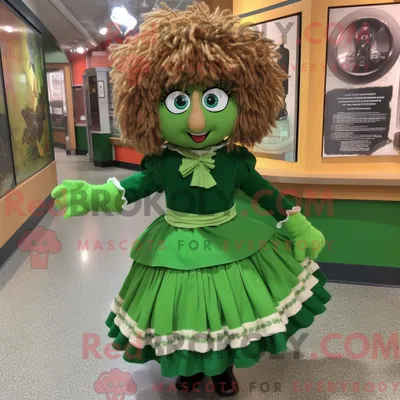 Productafbeelding van Mascottefiguur REDBROKOLY van een Olive Irish Dancer gekleed met een minirok en sjaalspelden