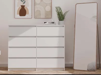 A white dresser with a tall mirror in a room.