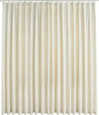 A full-frame shot of a cream-colored velvet curtain hanging from a rod.