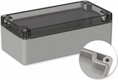 A light gray rectangular enclosure with a transparent lid, shown from a diagonal angle. A close-up inset shows the sealing mechanism of the lid.