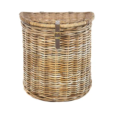 A wicker laundry basket with a leather strap and buckle.