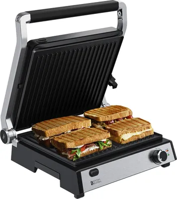 A kitchen appliance, a sandwich maker, with four sandwiches inside.