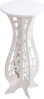 A white decorative plant stand with intricate cutouts.