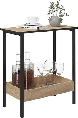 A side table with a decanter and glasses on the lower shelf, and a book, cup, and plant on the top shelf.