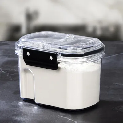 A transparent plastic storage container filled with white powder, placed on a dark, marbled surface.