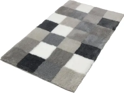 A bath mat with a checkered pattern of gray, white, and black squares.