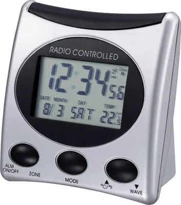 A digital alarm clock with a silver and black casing, displaying the time, date, and temperature.