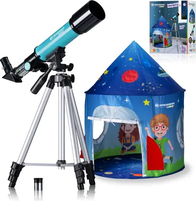 A turquoise telescope on a silver tripod is shown next to a blue children's play tent with a space theme. The tent has cartoon characters and stars on it. A small accessory for the telescope is on the floor.