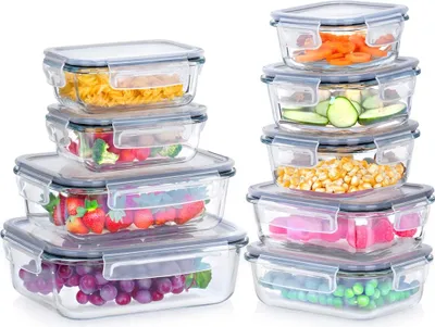 A set of glass food storage containers filled with various foods, stacked and arranged against a white background.