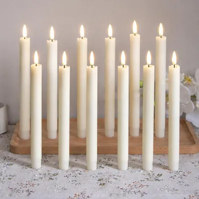 Immagine prodotto di 12 candele a LED a forma di bastoncino, luce bianco caldo, 25 cm, senza fiamma, alimentate a batteria, ideali per decorazioni natalizie, matrimoni, feste ed eventi, colore avorio