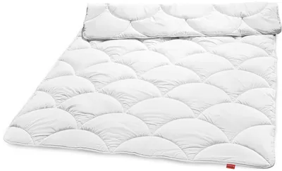 A white duvet with a scalloped pattern is laid out on a white background.