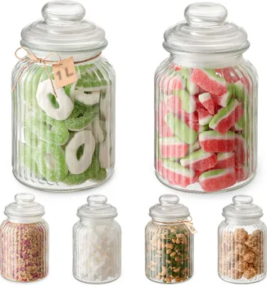 A collection of glass candy jars filled with various sweets, arranged on a white background.