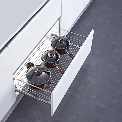 A kitchen drawer with pots and pans stored inside.