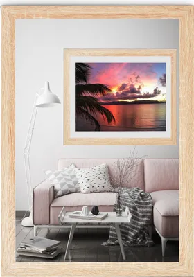A living room scene with a pink sofa, a coffee table, a floor lamp, and a framed picture on the wall.