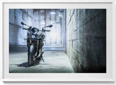 Produktbild von Motorrad in einer betonierten Gasse– Wandbild mit Rahmen – Gerahmtes Bild  – Wanddekoration – 100x70 cm –  Weiß Rahmen