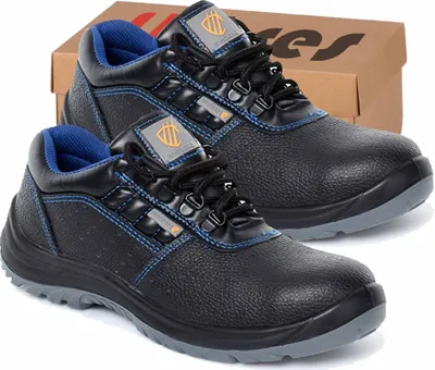 A pair of black work shoes with blue accents, placed in front of a cardboard box.