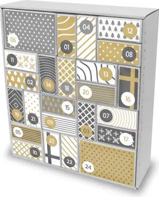 A close-up, angled view of a white cardboard advent calendar with various numbered boxes decorated with different patterns in gold and gray.