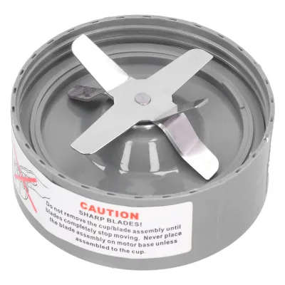 A close-up view of a blender blade assembly with a caution label.