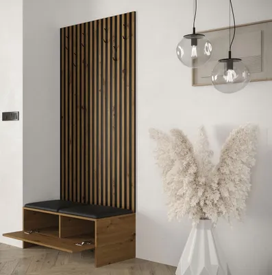 A modern entryway with a wooden slatted panel, a bench with storage, and decorative pampas grass in a vase.