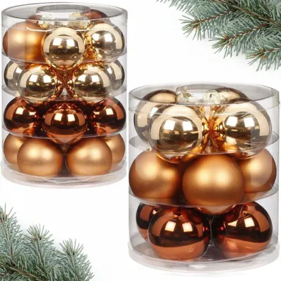 Two clear plastic containers filled with Christmas ornaments in gold and bronze colors, with pine branches in the foreground and background.