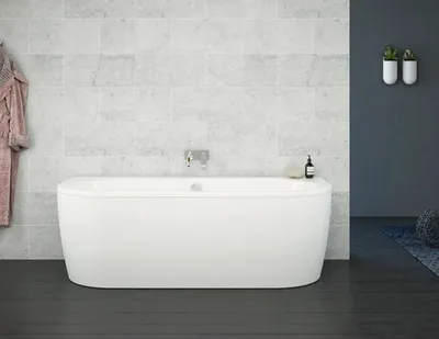A freestanding bathtub in a bathroom setting with tiled walls and dark flooring.
