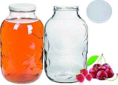 Two glass jars, one filled with orange liquid and the other empty, are displayed alongside a lid and some cherries and raspberries.