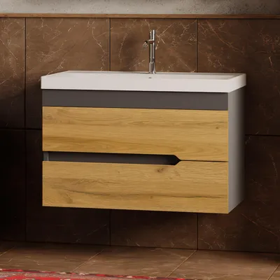 A bathroom vanity with a ceramic sink and faucet mounted on a marble-tiled wall.