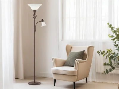 A floor lamp and an armchair are placed in a room with sheer curtains.