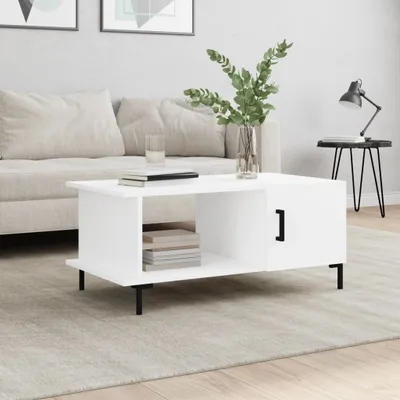 A modern living room scene featuring a white coffee table with a vase of greenery.