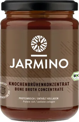 A jar of bone broth concentrate on a brown background.
