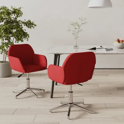 Two red chairs are placed around a marble table in a dining room.