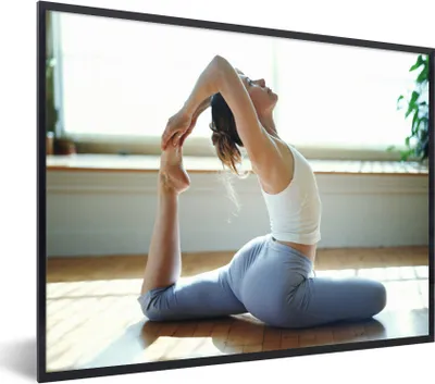 Produktbild von MuchoWow® Gerahmtes Poster Eine Frau praktiziert Yoga 80x60 cm - Poster mit Schwarzem Bilderrahmen Wandposter Rahmen Foto Bilder - Schwarzem - Mit Gestell